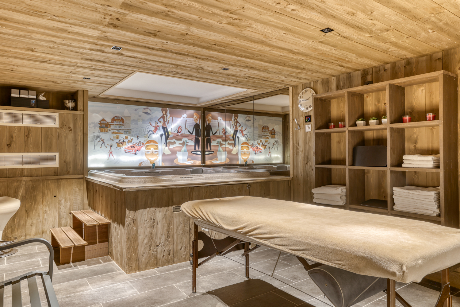 Espace spa avec table de massage et jacuzzi dans un chalet de montagne.