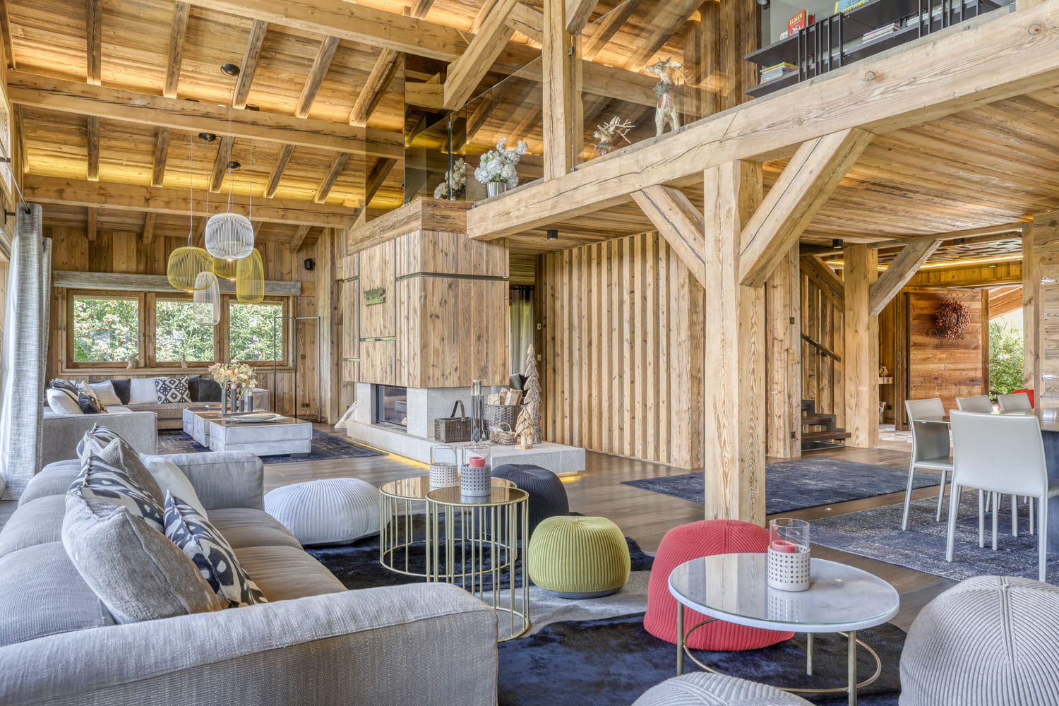 Grand espace de vie en bois avec salon et cheminée dans un chalet de luxe à Megève