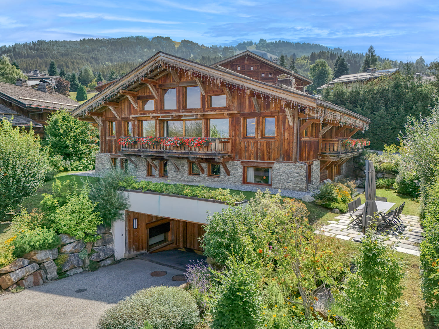 Chalet de luxe en bois à Megève avec jardin et terrasse en été