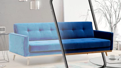 Image of a modern living room featuring a blue sofa. A smartphone in the foreground shows an augmented reality view of the same sofa, demonstrating how it would look in the room