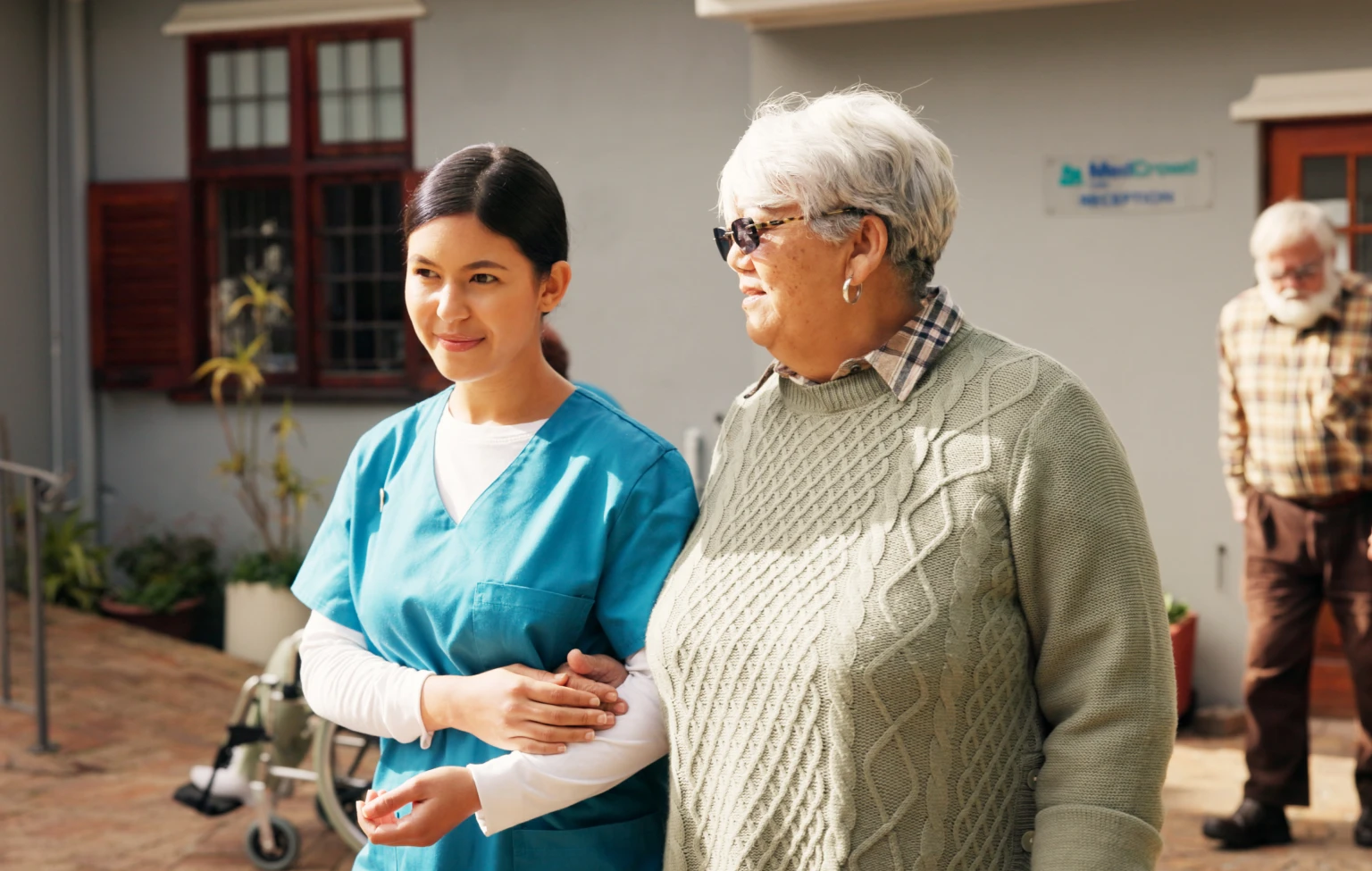Occupational therapist walking outdoors with an older adult, supporting whole-person care and well-being.