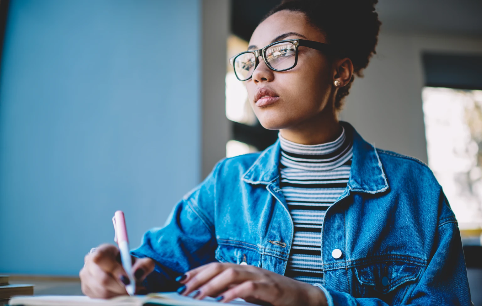 Occupational therapy student studying and taking notes at a desk.