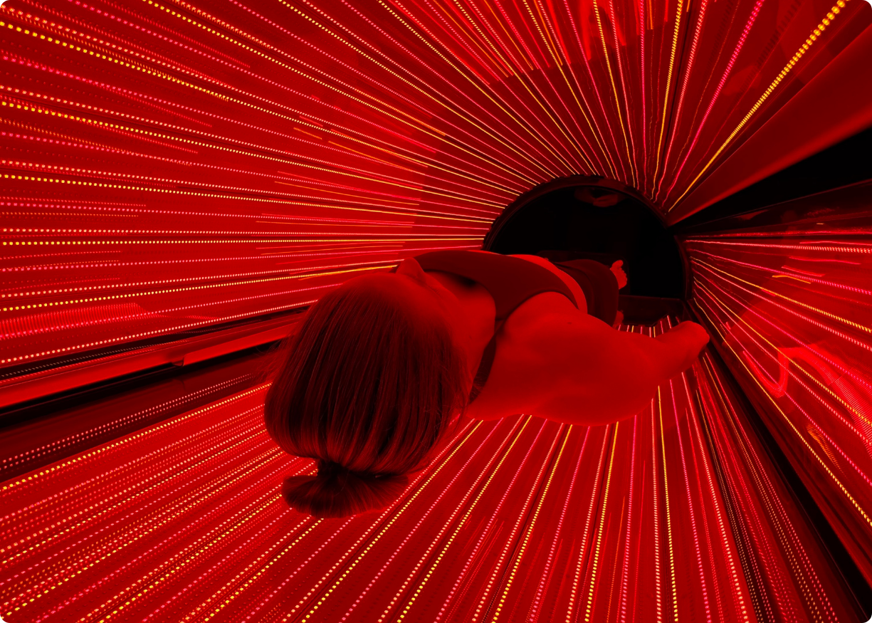 A woman lying in Red Light Pod from Lyfe Nordic