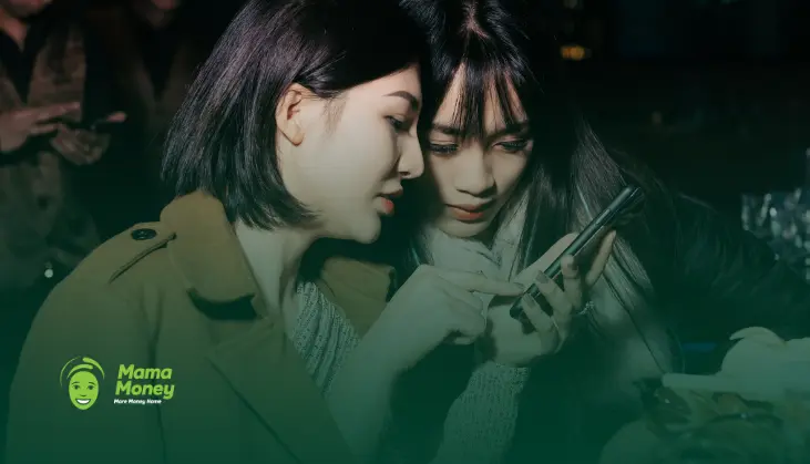 Two women using a smartphone to manage savings and international finances.