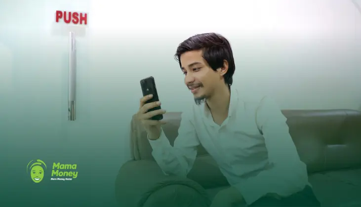Young man smiling while using his smartphone indoors, representing affordable ZAR to NPR money transfers from South Africa to Nepal.