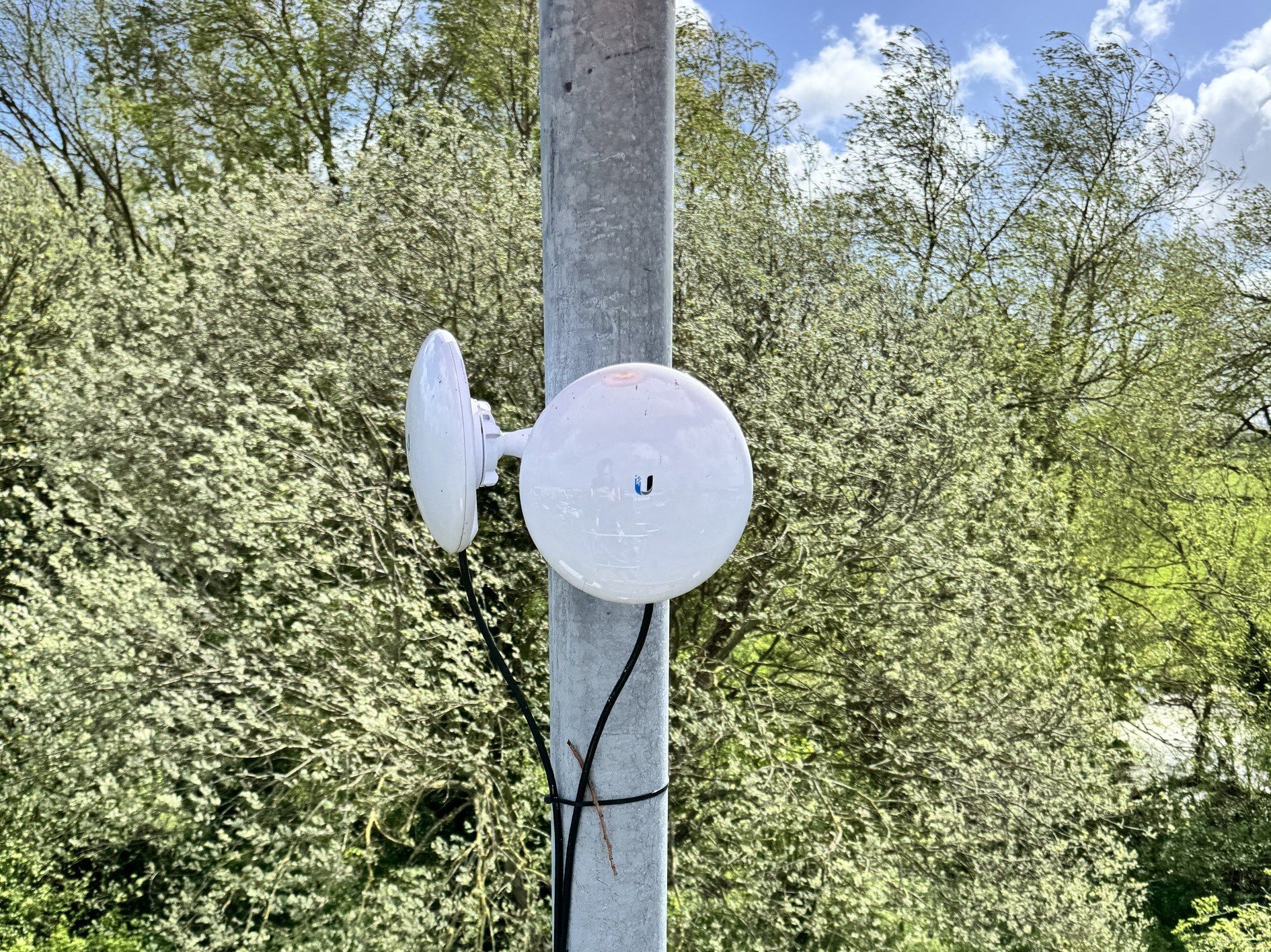 A point-to-point wireless radio link mounted on a pole, one way to connect a camera position where fibre cannot reach.