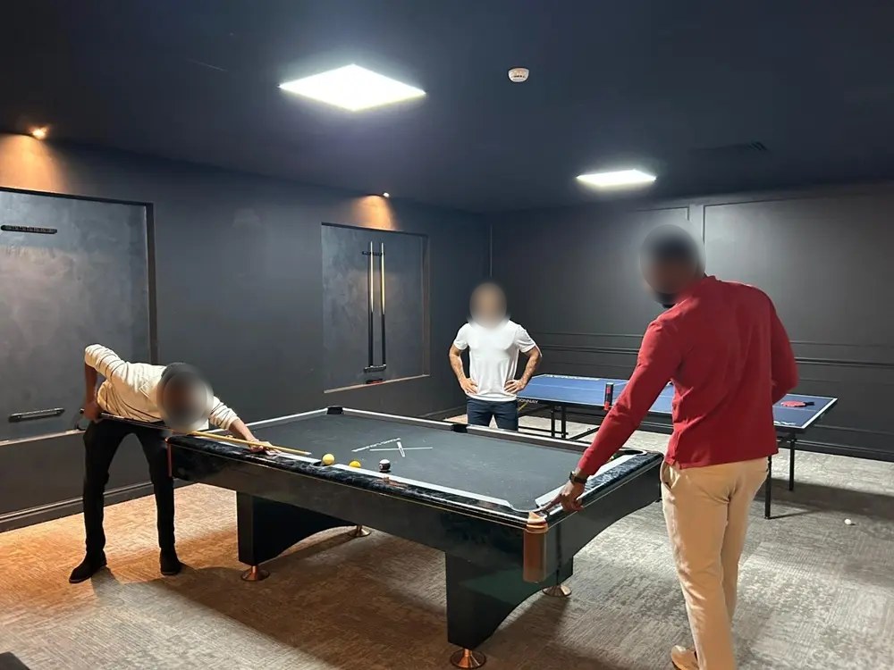 Friends playing pool in a private suite at FOMO Lounge Manchester