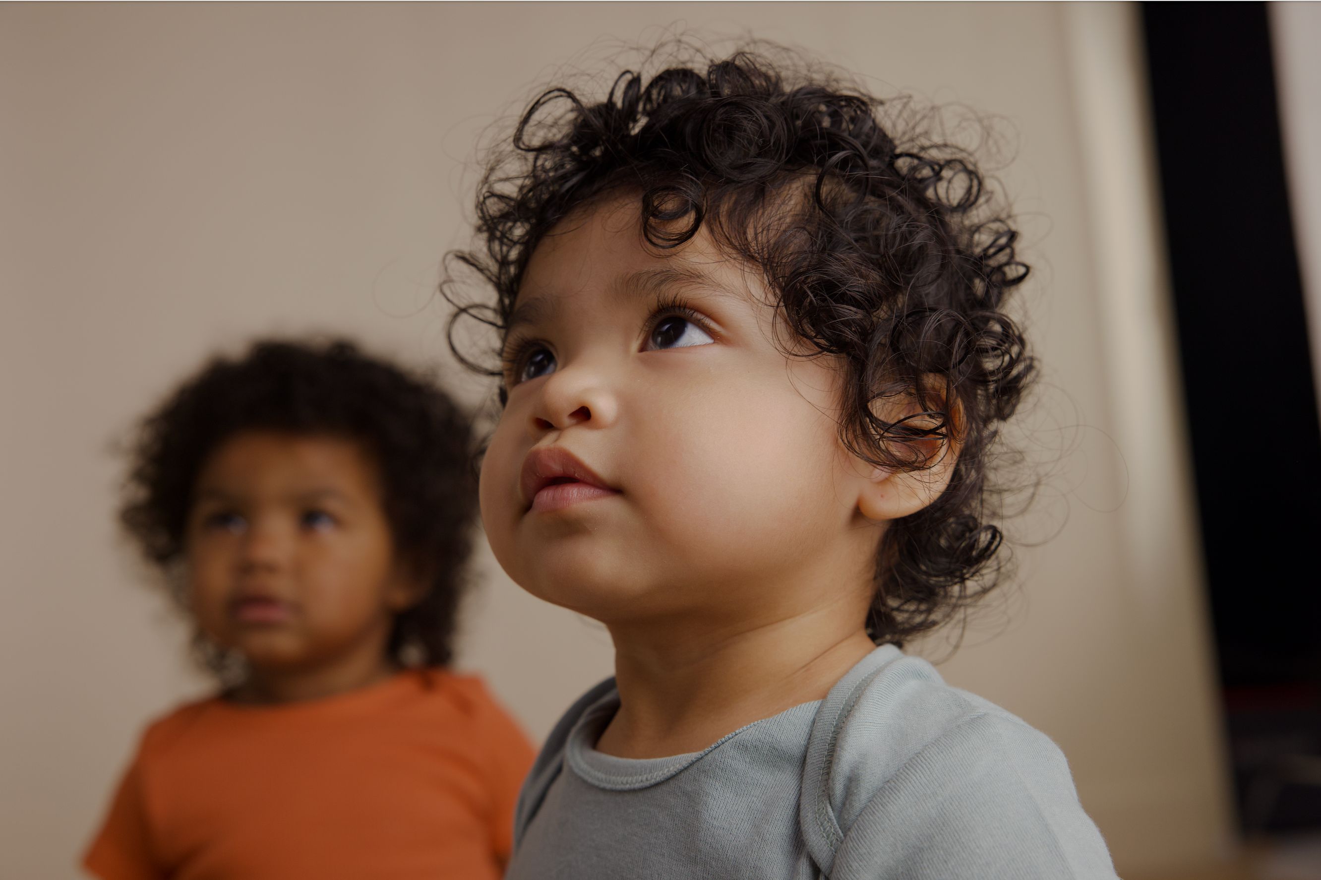 Baby looking up, second baby in background