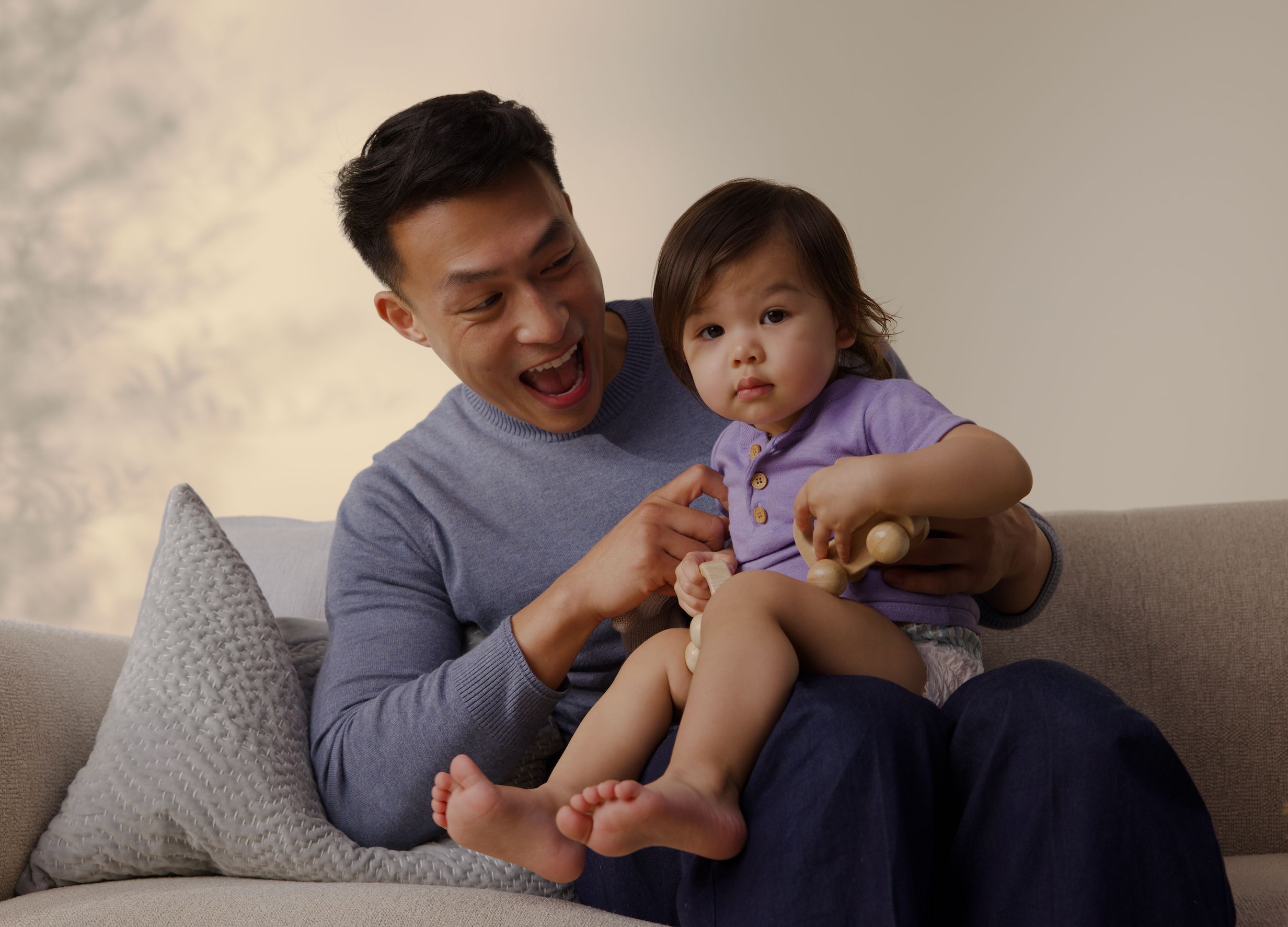 Dad playing with baby on Sofa