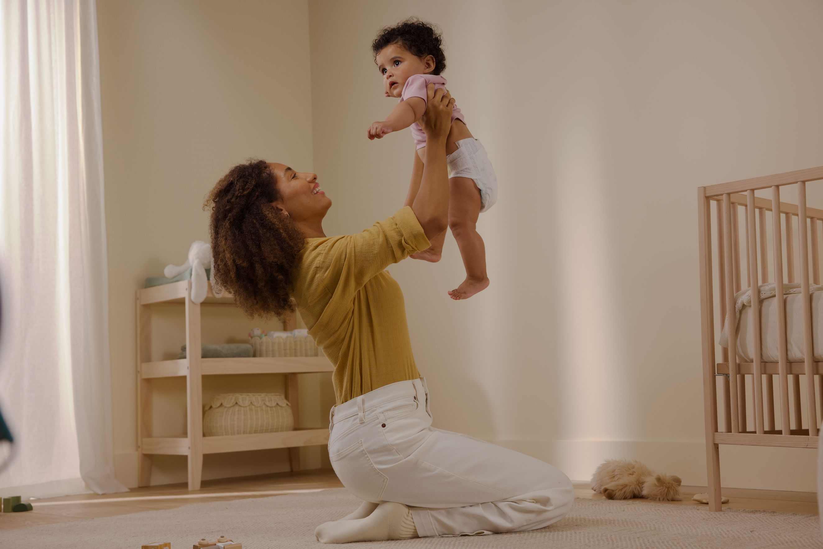 mom lifting up baby in air
