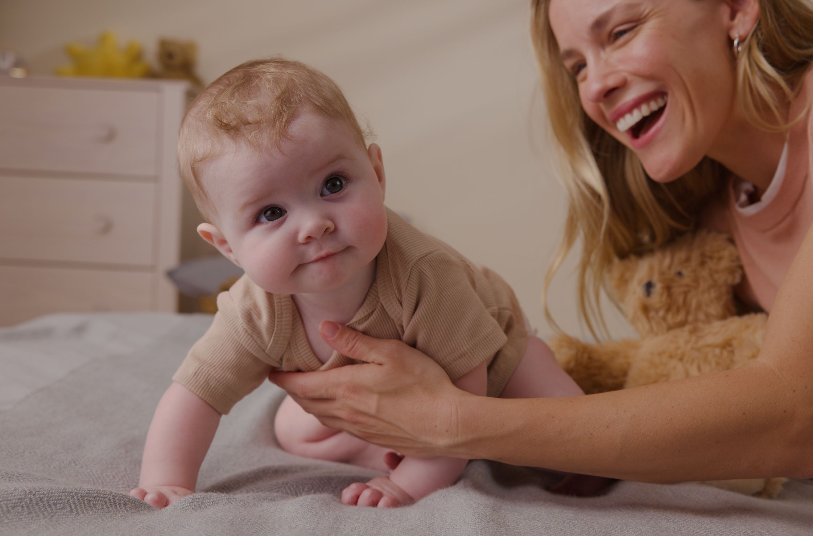 baby crawling with support of mom