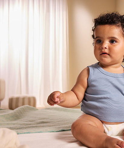 Baby in Diaper sitting on soft ground