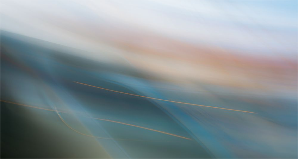 Yellow rubber duck on frosty vegetation beside a flowing stream in a snowy winter landscape.