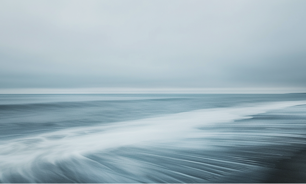 Yellow rubber duck on frosty vegetation beside a flowing stream in a snowy winter landscape.