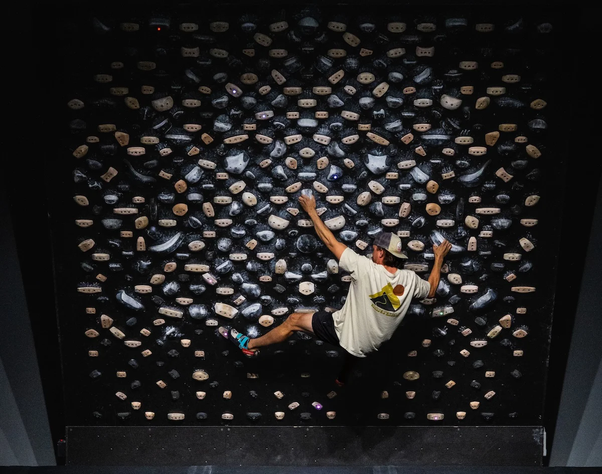 Climber doing a dynamic move on a Tension Board 2 (TB2) at Shift Climbing gym