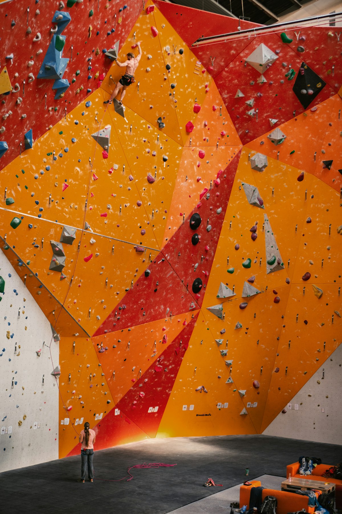 Orange and red climbing holds on a bouldering wall