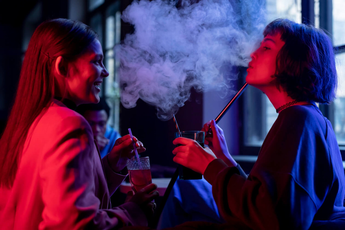 A group of teens vaping through a hookah
