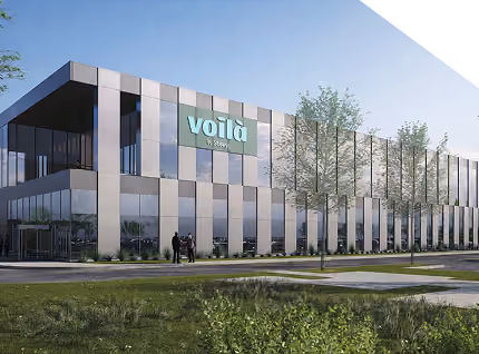Modern office building with glass panels and Voilà logo on the facade under clear sky.