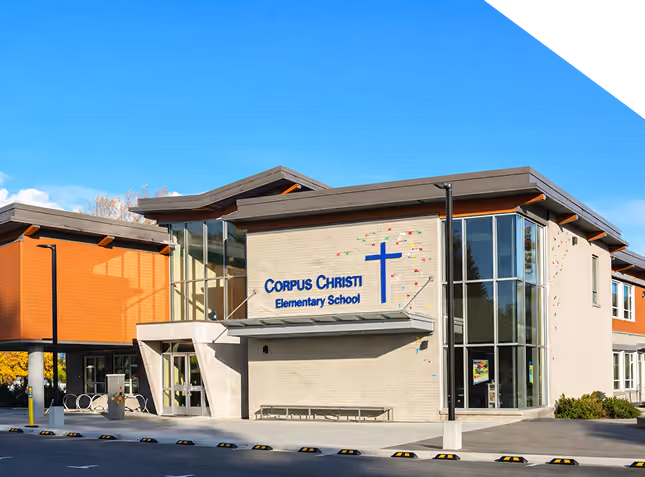 Exterior of Corpus Christi Elementary School building under clear blue sky.