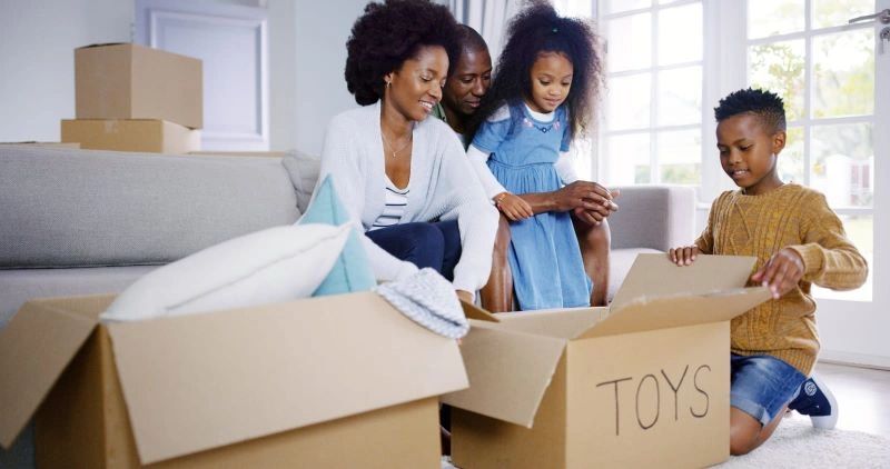 family moving with kids and unpacking toys in a new home