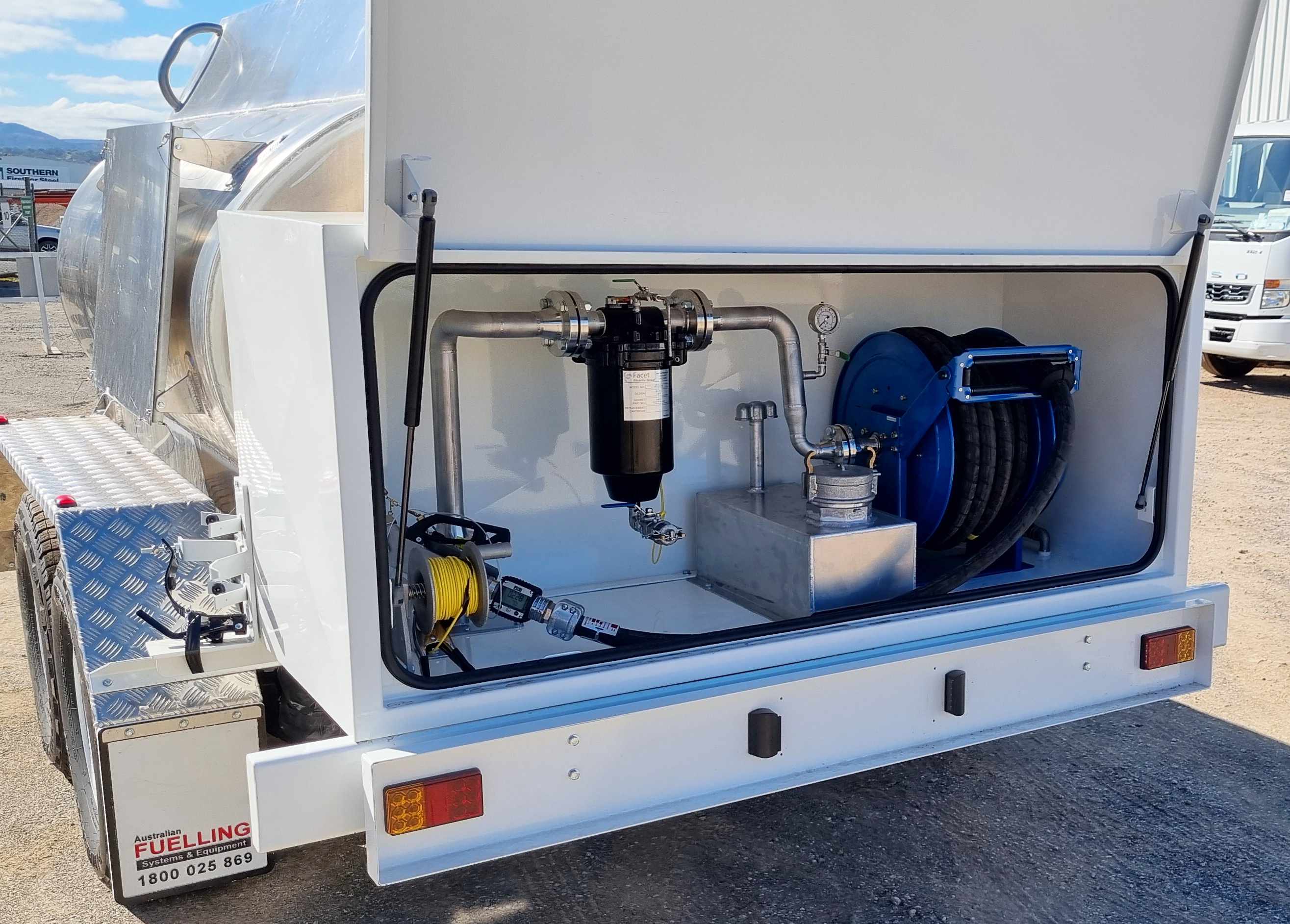 Rear cabinet open showing reel, delivery hose, nozzle with digital flow meter, slops tank, pressure gauge, static reel and Facet fiter housing