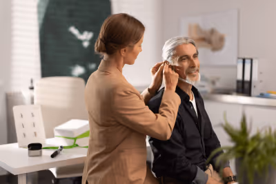 Personne essayant un appareil auditif dans un cabinet