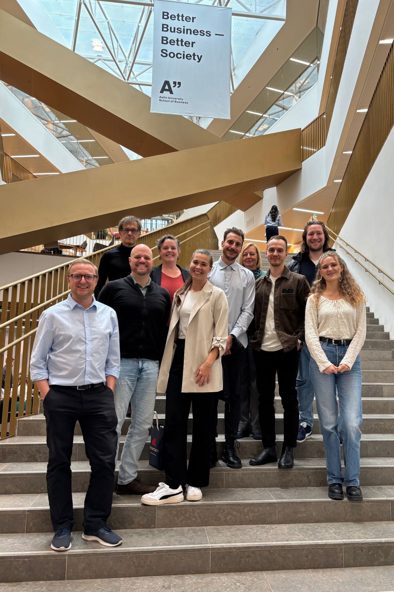 Group of people standing on a staircase at Aalto University.