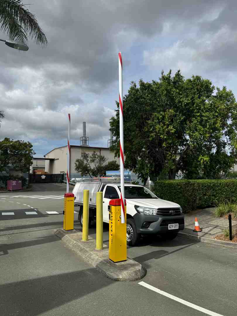 An automatic boom gate at the entrance to a commercial property, with a delivery truck approaching. - Security at Scale: What Growing Businesses Often Forget