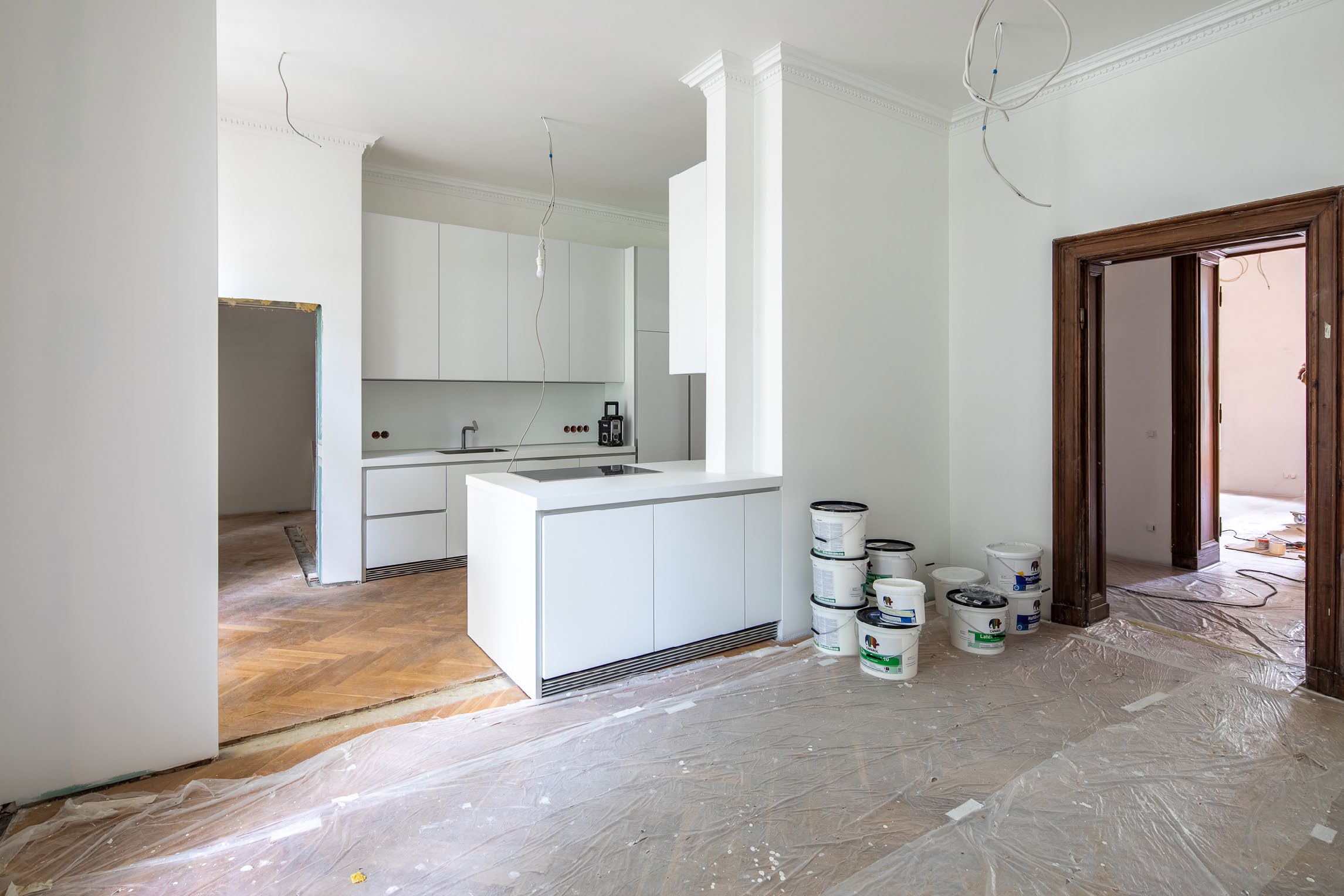 Moderne Küche mit weißen Schränken in einer Altbauwohnung bei Renovierung mit Malereibedarf.
