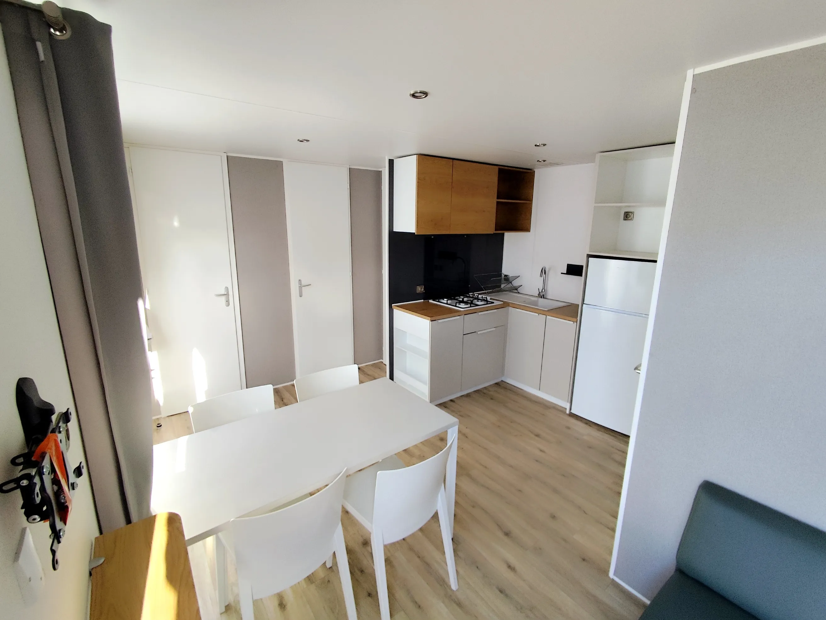 pièce à vivre avec cuisine équipée coin salon coin repas devant la baie vitrée mobil home o'hara mobil home de 2019 mobil home récent mobil home occasion mobil home baie vitrée mobil home révisé msmh mobil home  livraison gratuite