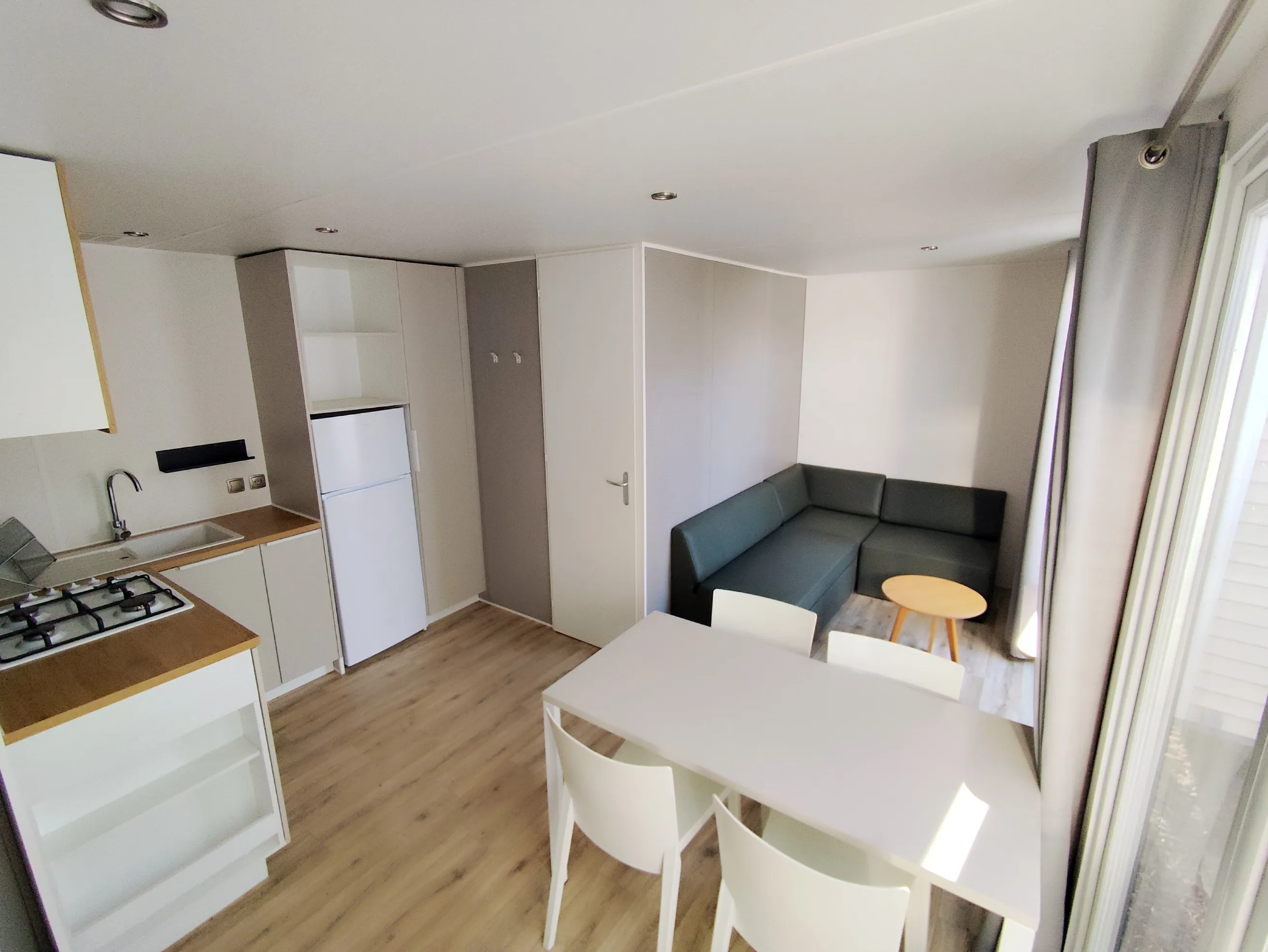 pièce à vivre avec cuisine équipée coin salon coin repas devant la baie vitrée mobil home o'hara mobil home de 2019 mobil home récent mobil home occasion mobil home baie vitrée mobil home révisé msmh mobil home  livraison gratuite