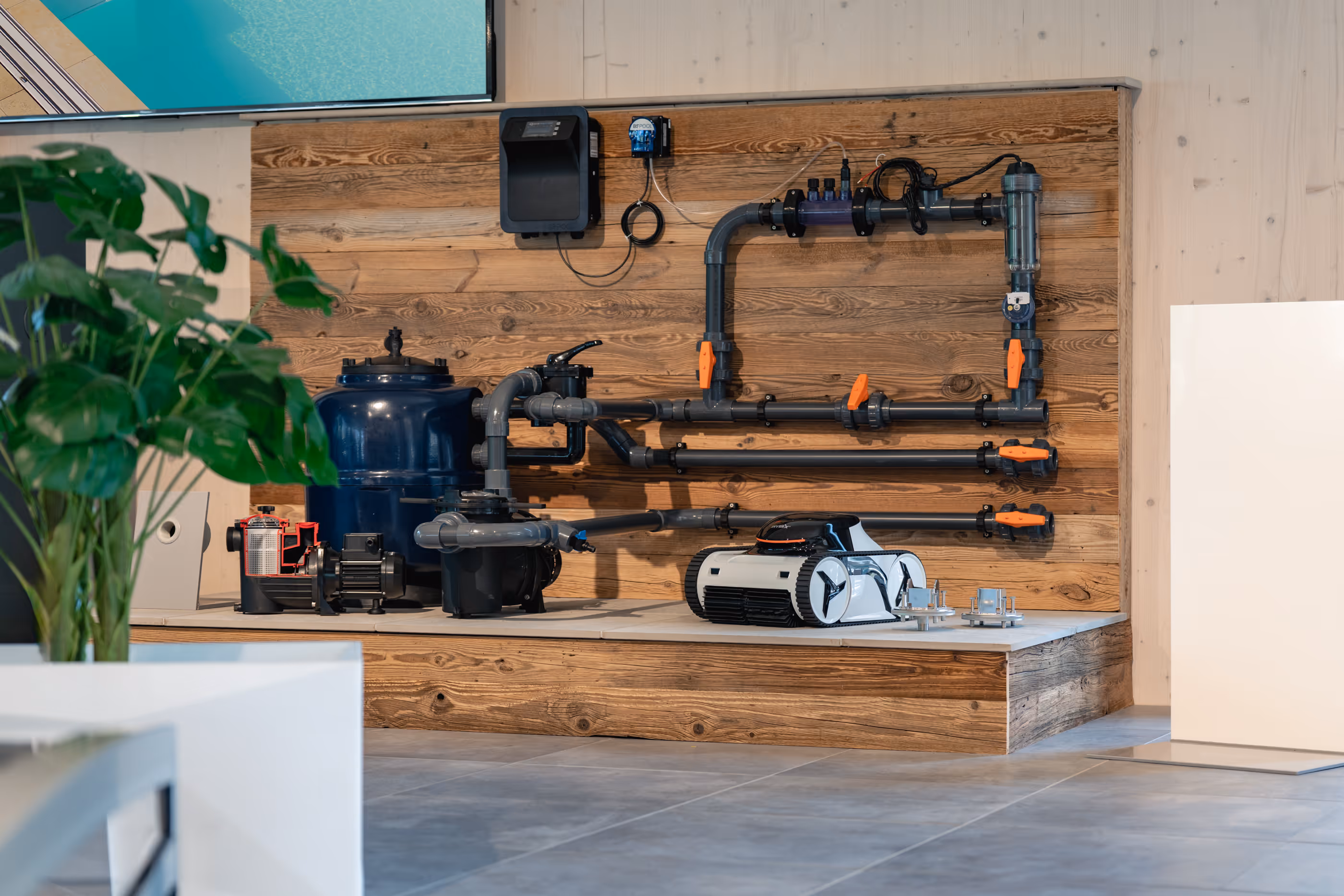 Moderne Pooltechnik mit Rohren, Ventilen, Filtern und einem Reinigungroboter an einer Holzwand montiert.