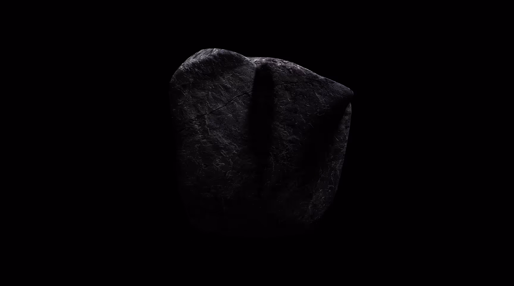 Dunkler, grob strukturierter Graphitstein vor schwarzem Hintergrund.