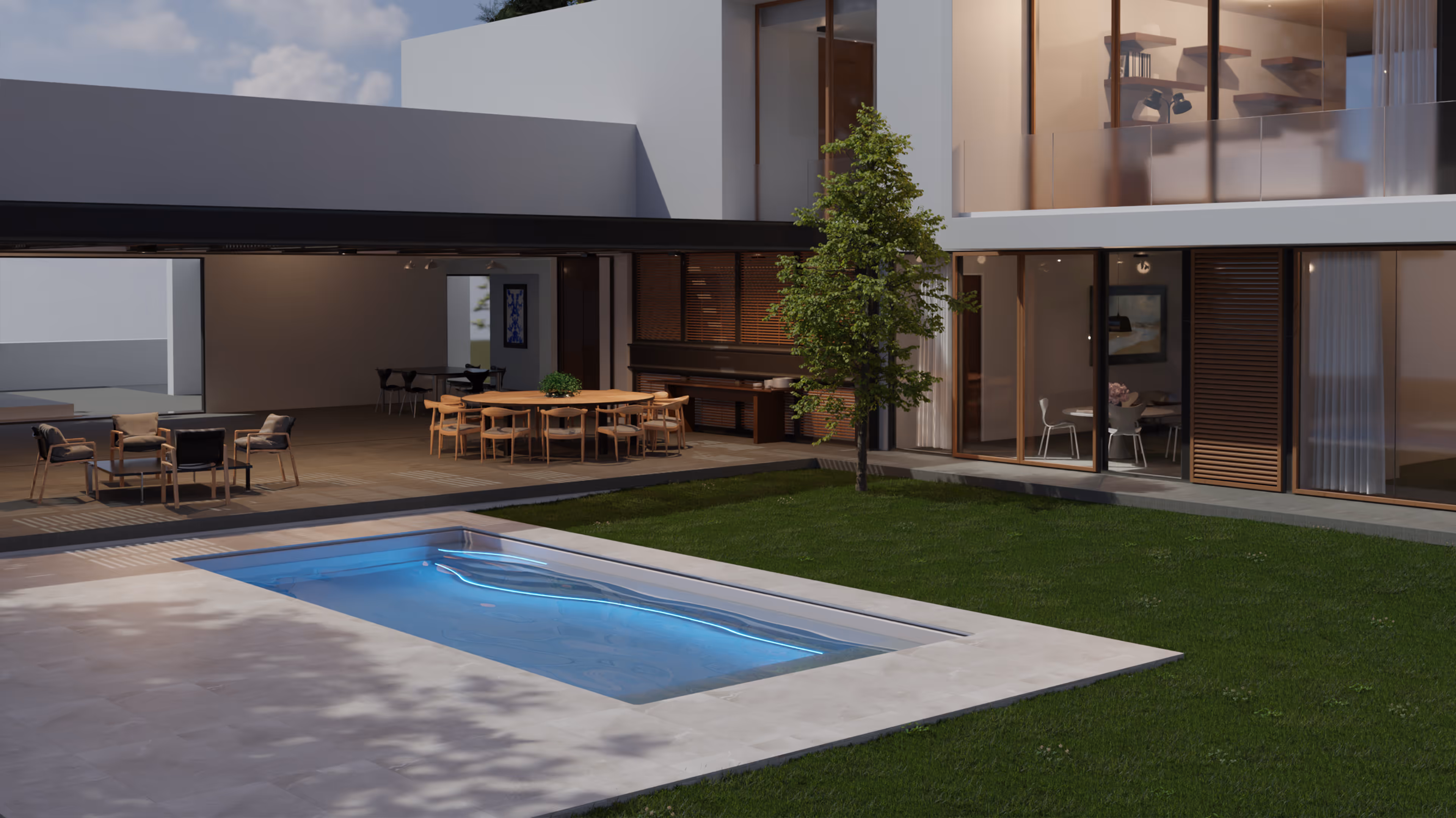 Modern Haus mit beleuchtetem rechteckigem Pool, Terrasse mit Sitz- und Essbereich und einem Baum im Garten.