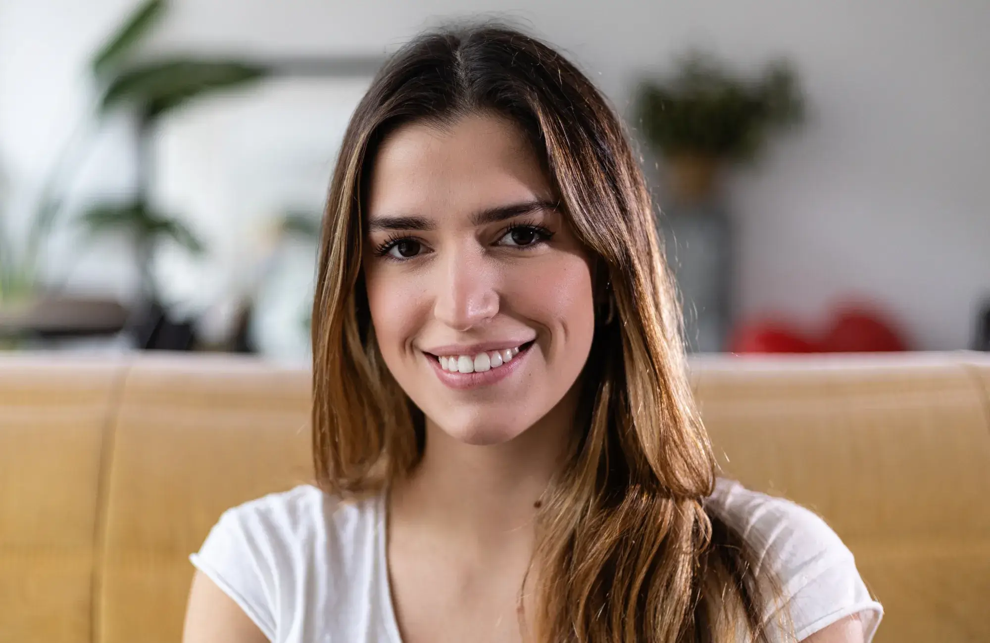 A woman sitting on a couch with a smile on her face.