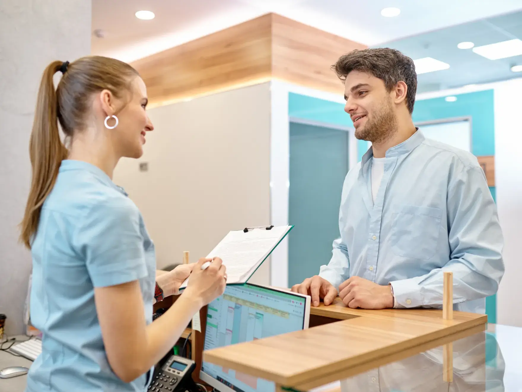 A man and a woman standing in front of a desk.