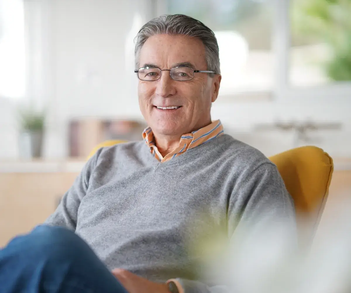 A man sitting in a chair with a smile on his face.