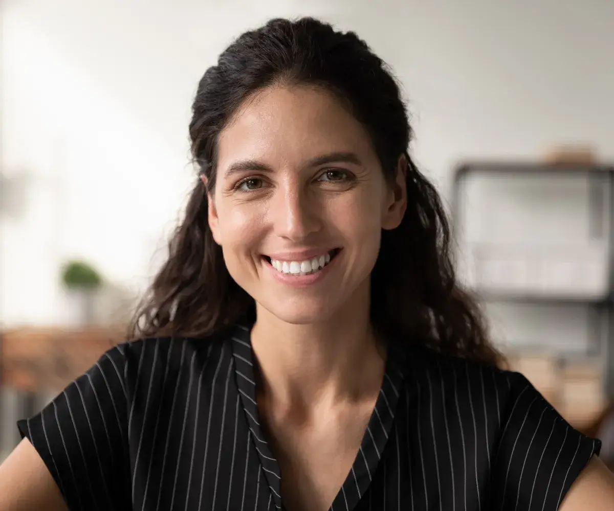 A smiling woman in a black and white shirt.