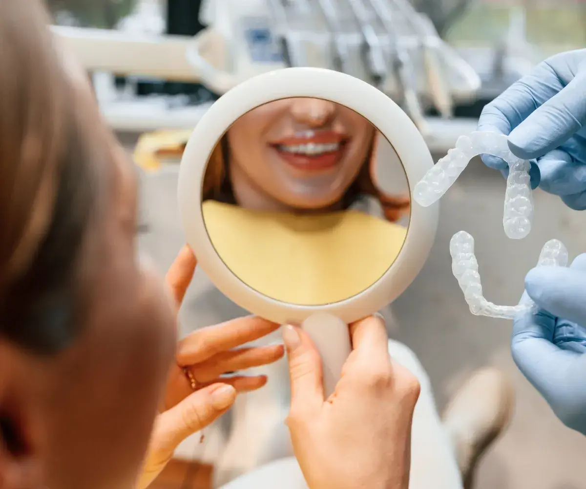 A woman getting her teeth brushed by a dentist.