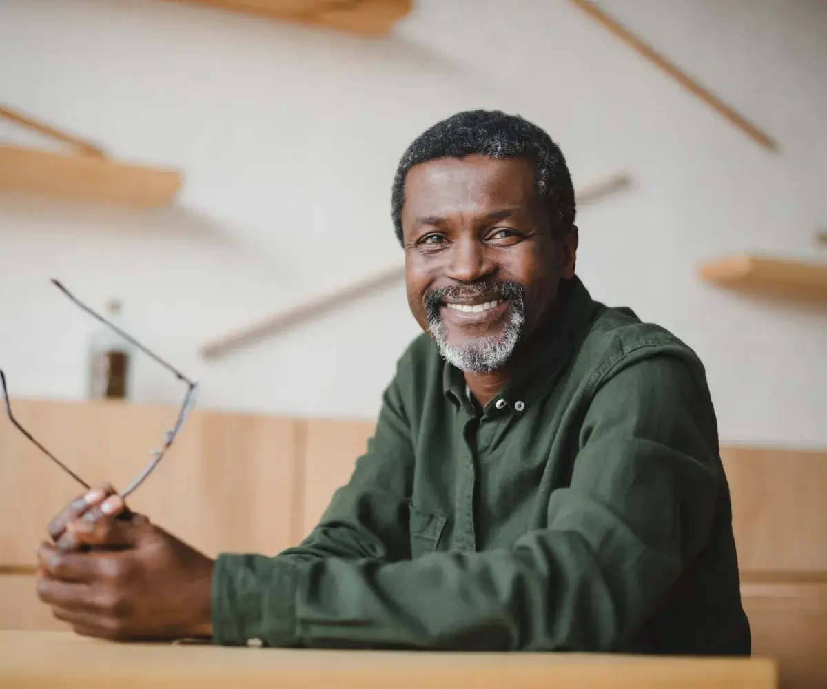 A man sitting at a table holding a pair of scissors.