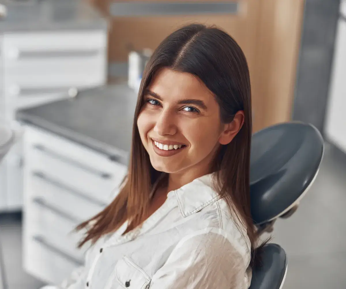 A smiling woman sitting in a dental chair.