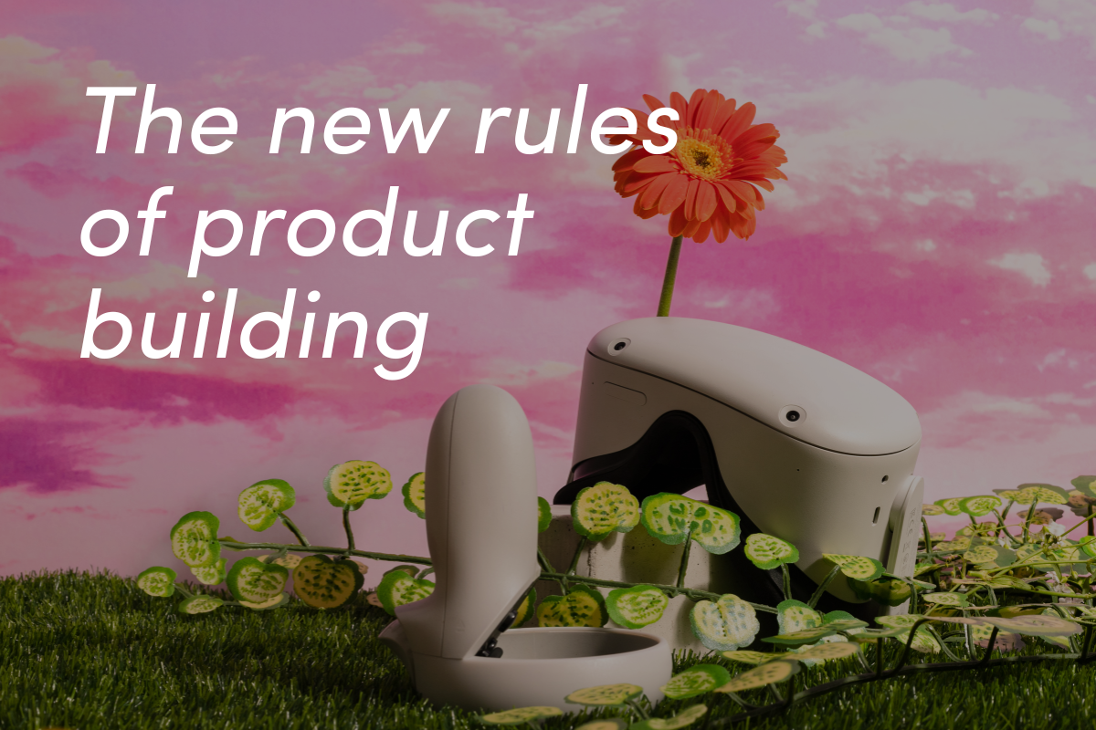 White robotic device on grass with orange flower and sliced vegetables under pink cloudy sky.