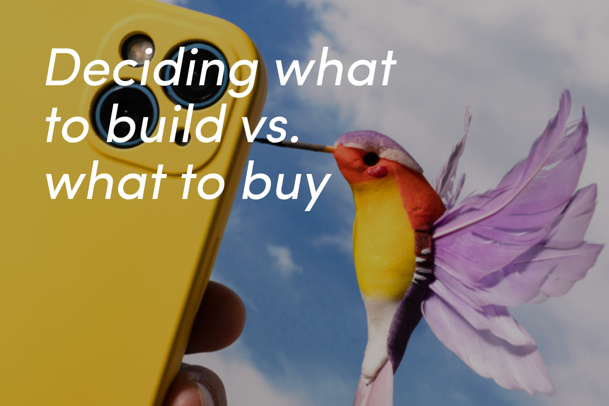 Yellow handheld device with colorful hummingbird featuring purple wings against blue sky background.