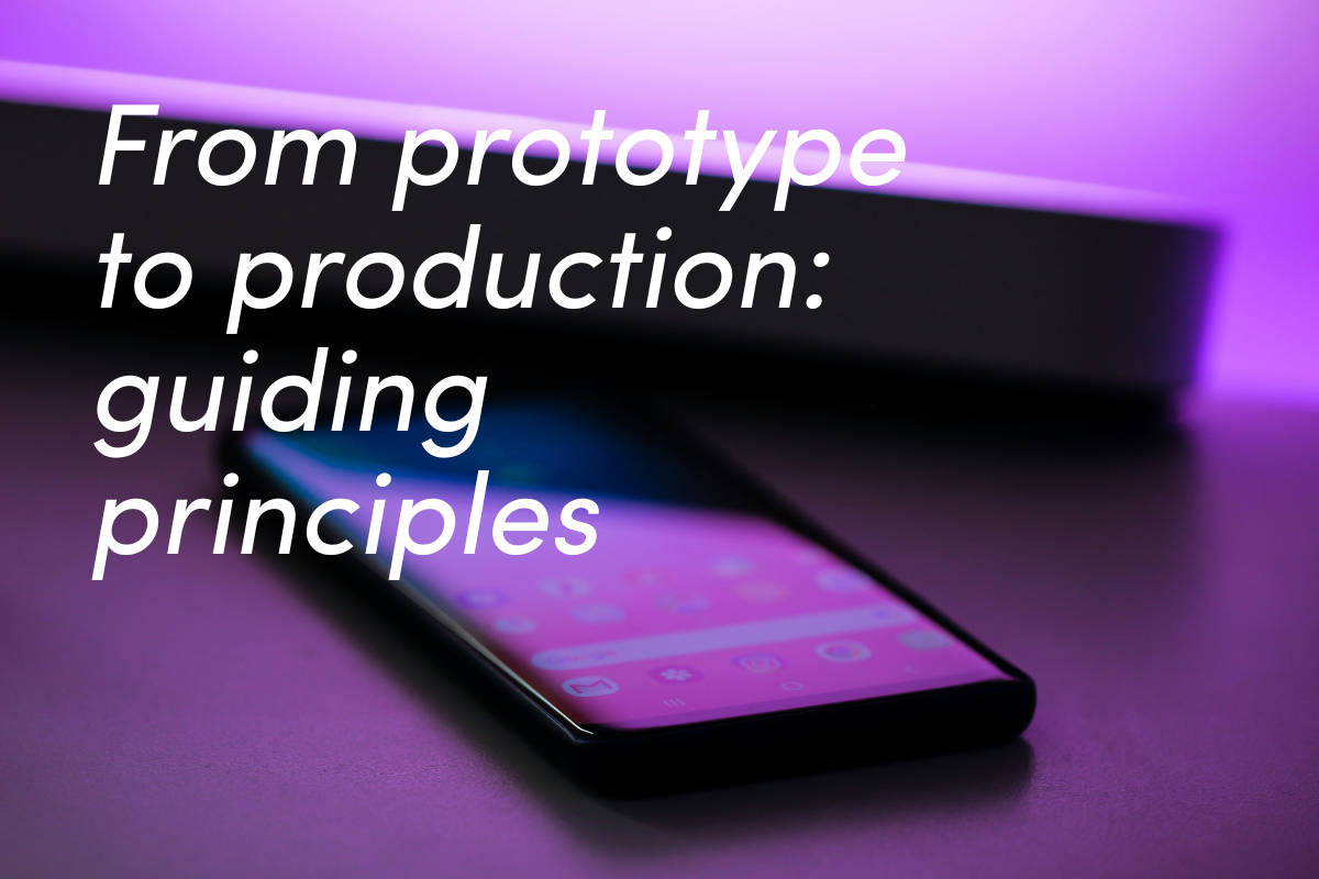 Black smartphone lying on reflective surface with purple and pink gradient lighting.