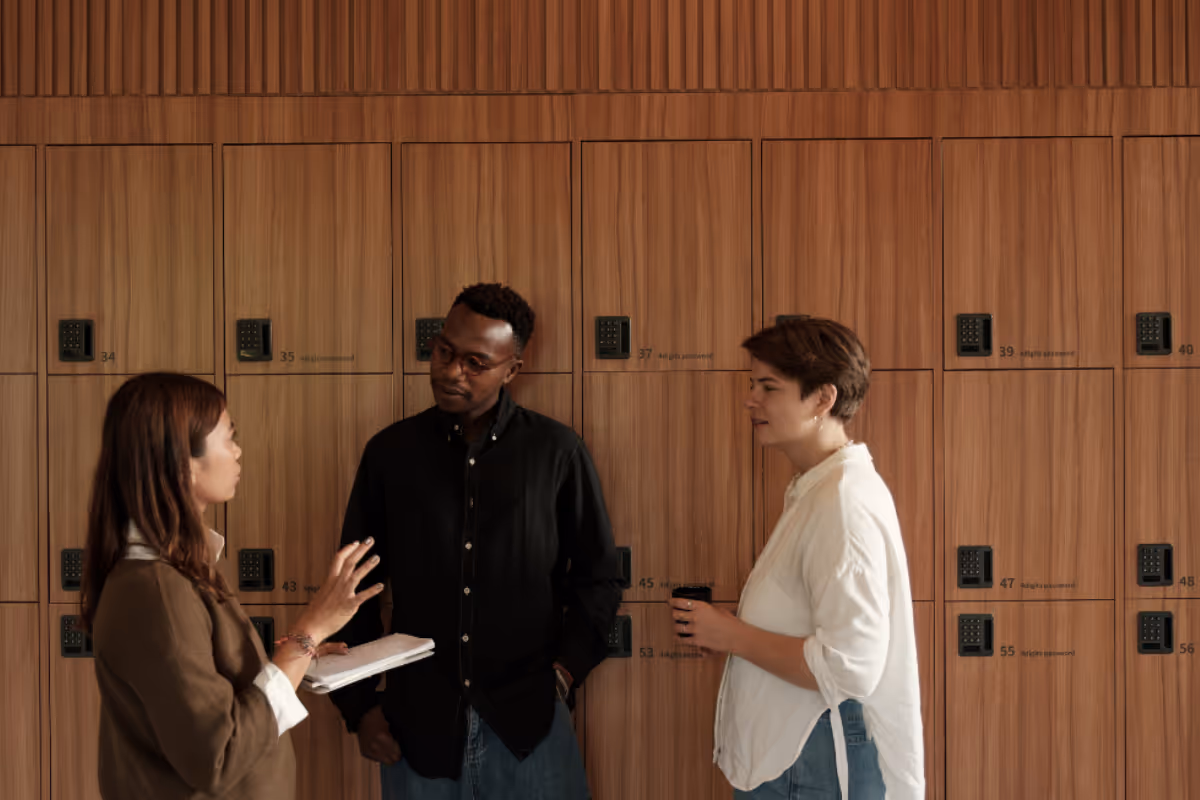Three diverse team members collaborating on product strategy planning in modern office environment