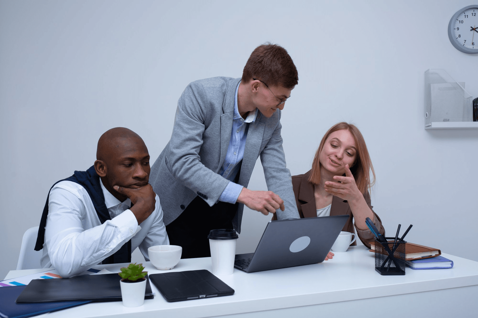 People working together around a laptop - Best Customer Service Automation Software