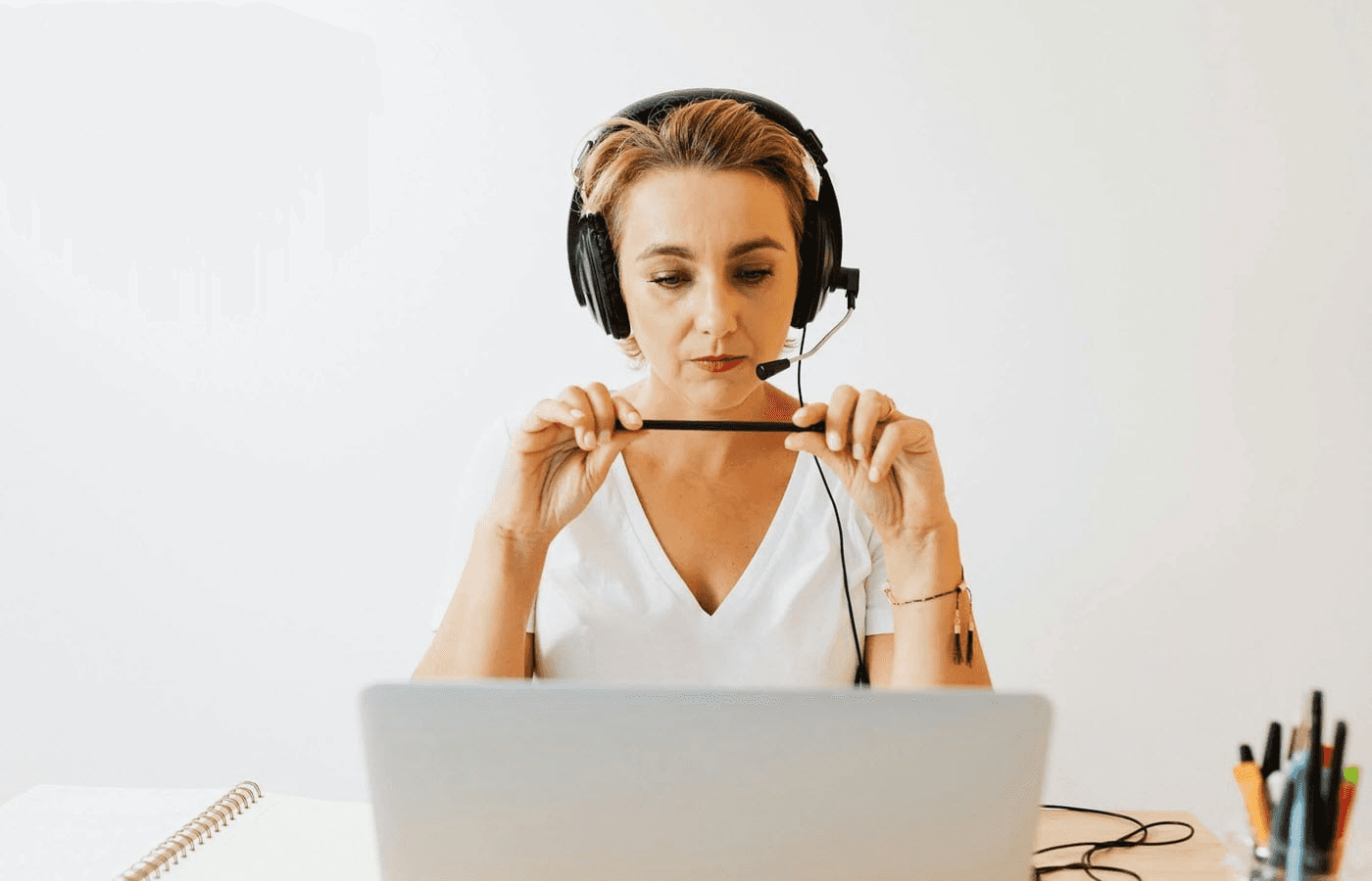 Woman wearing headphone holding black pen - Best IVR Experience