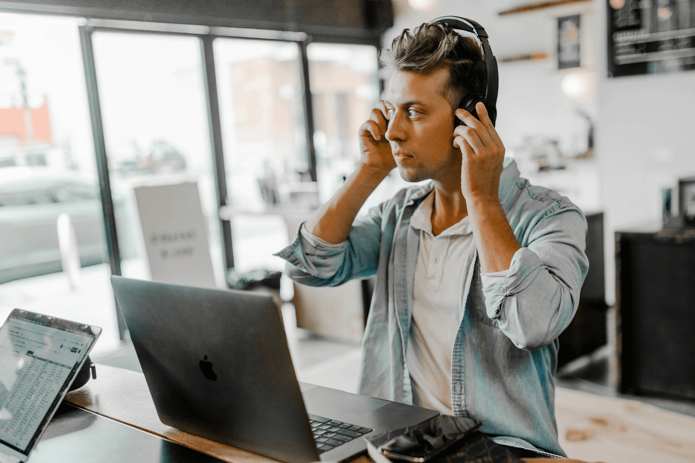 Man with headphones using a laptop - Best IVR System for Small Business