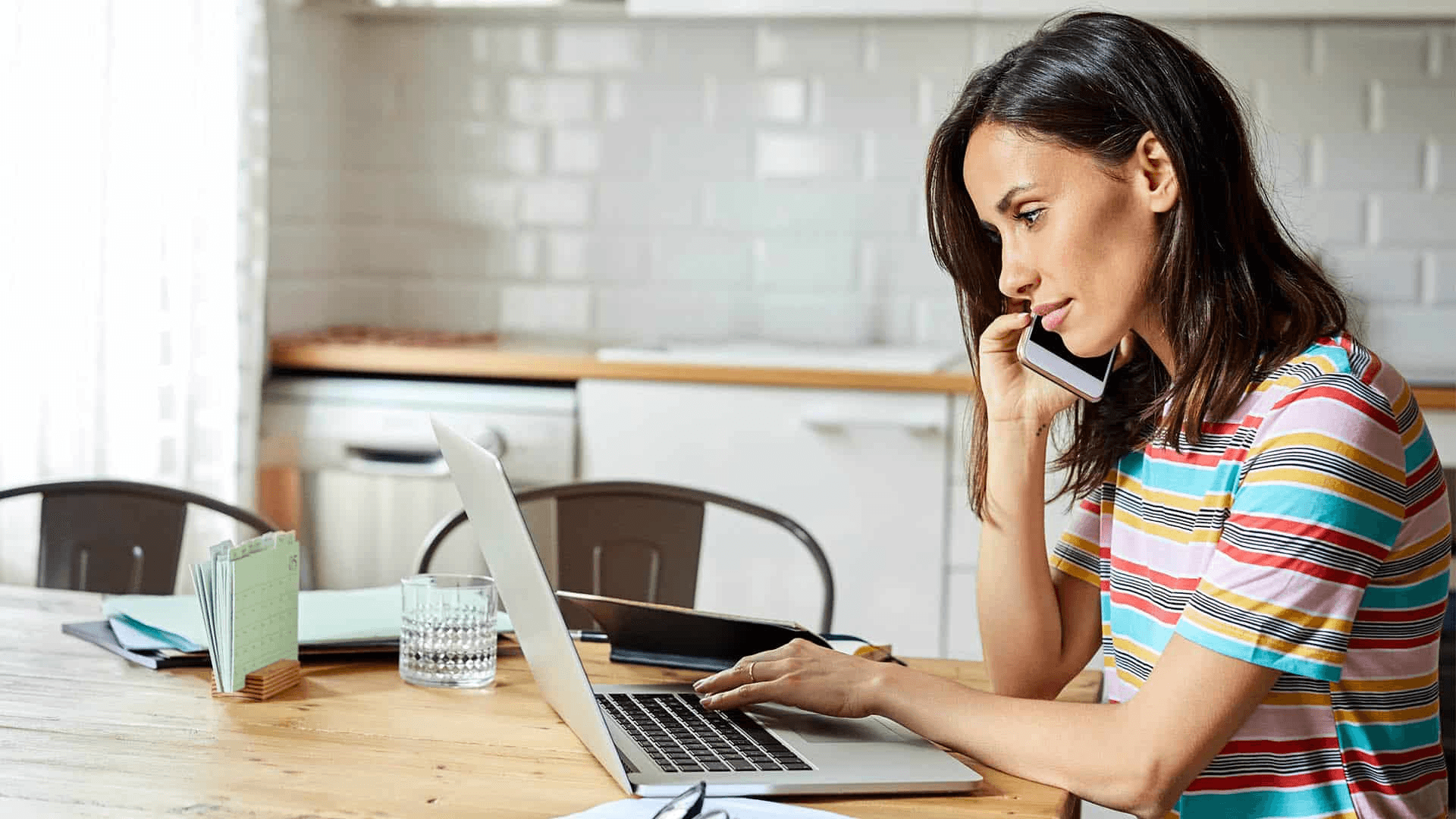 Woman using laptop while on phone - How Do You Manage Inbound Calls?