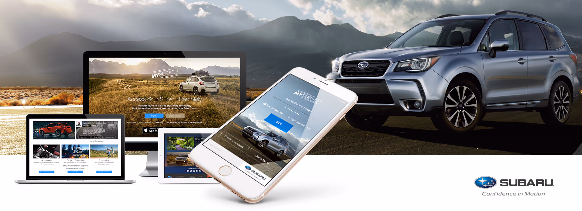 Silver Subaru SUV next to digital devices displaying MySubaru app and website with mountainous landscape background.
